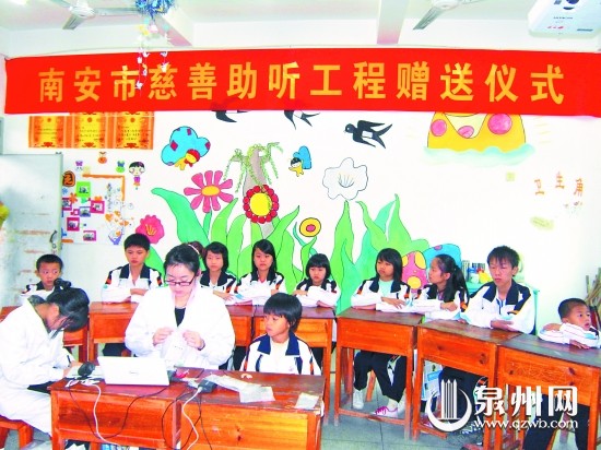 工作人員為失聰兒童安裝助聽(tīng)器