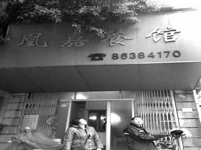 洪鳳媚站在自家店門口，看著“凰嘉餐館”4個字黯然