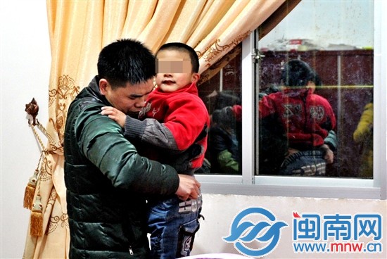 爸爸許先生，為玩鬧的小兒子整理褲子