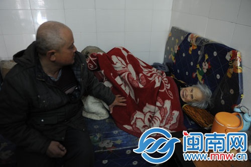 譚長福的家有點背陰，床沒有床墊，被子沒有被套