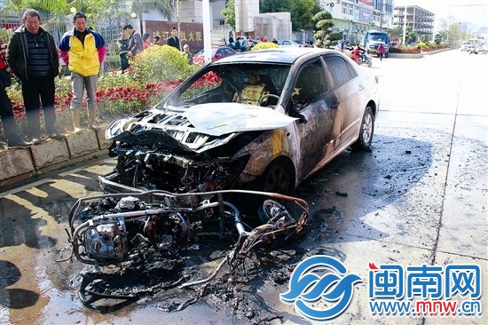 火被撲滅后，小車前躺著一輛被燒得只剩鋼架的助力車