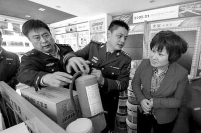 消防人員正在檢查一商鋪內的消防器材