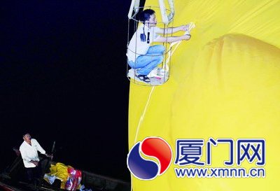 工人給大黃鴨系上繩子，準(zhǔn)備起吊