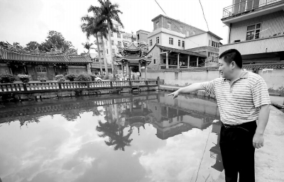姚河水在孩子落水的池塘邊向記者回憶事情經過。