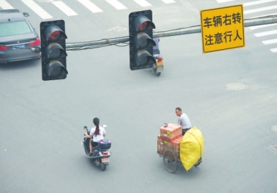 闖紅燈、不戴頭盔現(xiàn)象時(shí)有發(fā)生。本報(bào)記者陳明哲攝