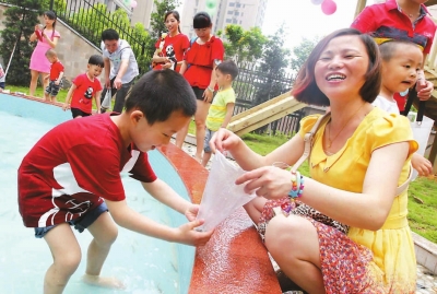 市第二幼兒園孩子與家長(zhǎng)一起玩抓泥鰍。