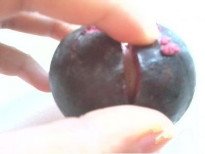 用菜刀，沿著其中兩瓣果肉的縫隙切下去