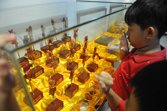 幼兒園小朋友好奇地盯著精致的妝糕人工藝品