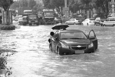 車主正在推行在積水中熄火的車輛