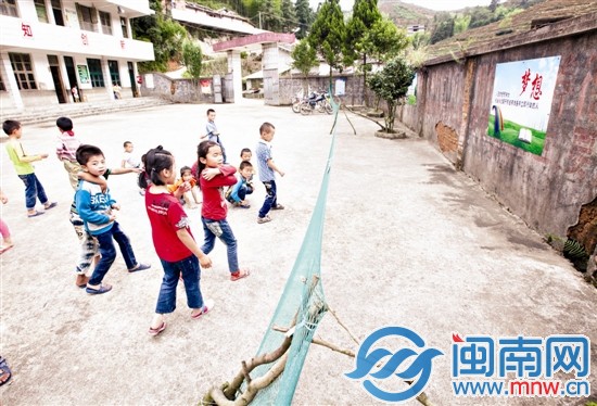 幾名小學生在操場上玩，學校的圍墻歪了一邊，用簡易