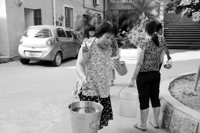 新華花苑小區(qū)居民挑水度日。實(shí)習(xí)生鄭智鴻攝