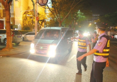 交警攔下濫開遠(yuǎn)光燈車輛。本報(bào)記者朱晨輝攝