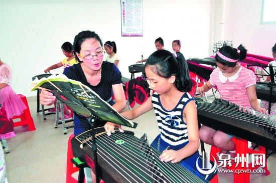 老師在指導學生彈奏古箏