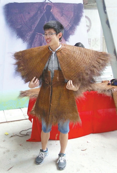 來賓興致勃勃地試穿陳奕培制作的蓑衣。