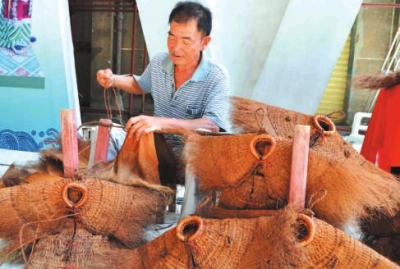 蓑衣制作傳承人詩山鎮(zhèn)鵬峰村的陳奕培在現(xiàn)場制作蓑衣。