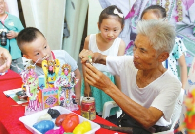 肖其昌在傳授小朋友妝糕人制作技藝。