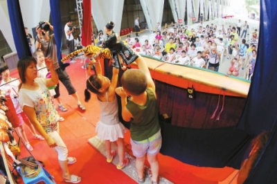 掌中布袋戲培訓(xùn)班的小朋友在臺上表演布袋戲《武松打