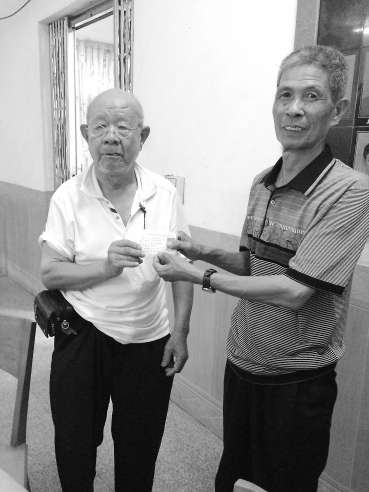 吳基揚（左）將辦好的證件遞交給村民。