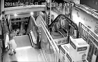 監(jiān)控顯示，白衣“熊孩子”按下電梯的緊急停止按鈕。