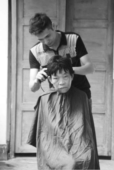 梁江華正在給老人理發(fā)。